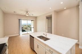 A kitchen with a large island and a fan.