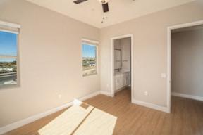 A room with a window overlooking a body of water and a wooden floor.