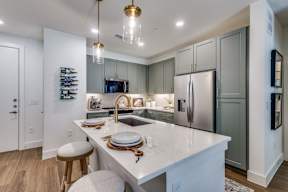 A kitchen with a white countertop and a refrigerator.