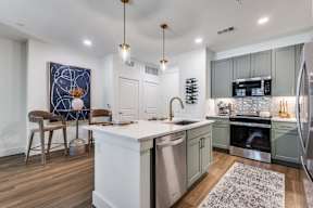 A modern kitchen with a white island and stainless steel appliances.