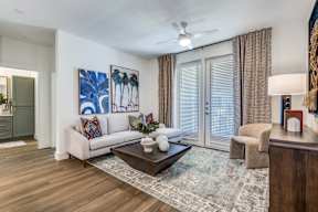 A living room with a white couch, a coffee table, and a painting on the wall.