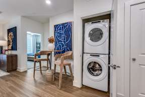 A modern laundry room with a washer and dryer stacked on top of each other.