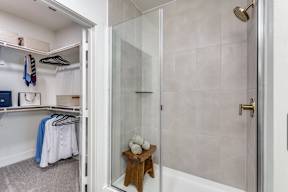 A bathroom with a walk-in shower and a white door.