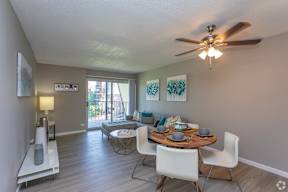 A dining room with a table set for two and a ceiling fan.