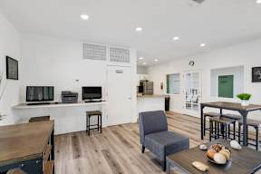 A living room with a grey armchair and a wooden table.