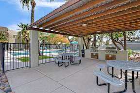 A patio with a table and chairs under a roof.