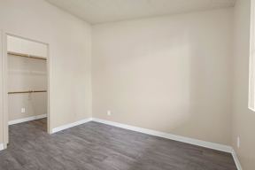 Empty room with grey flooring and white walls.