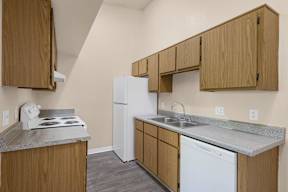 A kitchen with a white refrigerator, a stove, and a dishwasher.