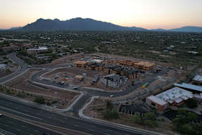 A construction site in a desert with mountains in the background.