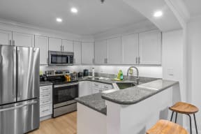 a kitchen with white cabinets and a gray counter top