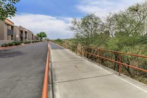 A long road with a metal railing on the side.