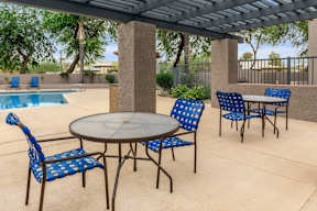 A patio with a table and chairs under a roof.