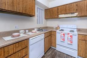 A kitchen with wooden cabinets and white appliances.