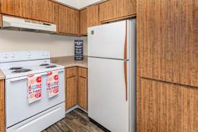 A kitchen with a white fridge and a white stove.