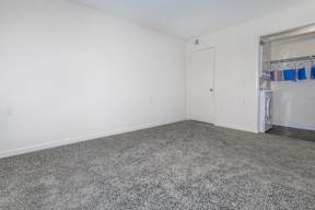 A room with a grey carpet and a white door.