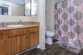 A bathroom with a wooden vanity and a white toilet.
