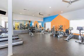 A gym with treadmills, weights, and exercise machines.
