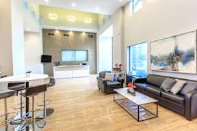 A modern living room with a black leather couch and a white coffee table.