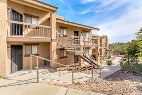 A sunny day at a beige apartment complex with a clear blue sky.