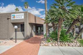 A leasing office building with a brick pathway leading to the entrance.