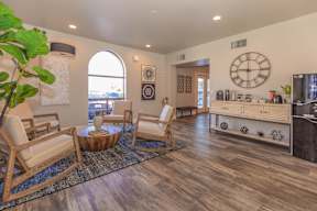 A living room with a wooden floor and a large clock on the wall.