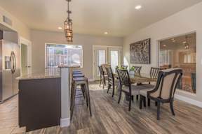 A kitchen with a bar and chairs.