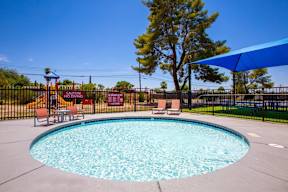 A round blue pool with a black fence around it.