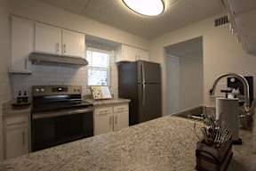 A kitchen with a stove, refrigerator, and sink.at Icon Apartments, Arizona