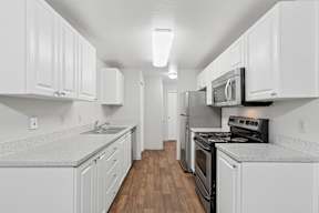 A kitchen with white cabinets and black appliances.