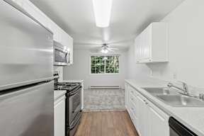 A modern kitchen with stainless steel appliances and white cabinets.