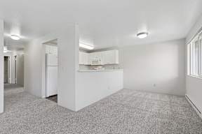 A white kitchen with a refrigerator, cabinets, and a countertop.