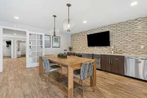 A modern kitchen with a wooden table and chairs.