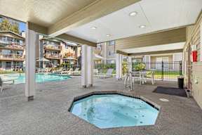 A hot tub sits in the middle of a patio area.
