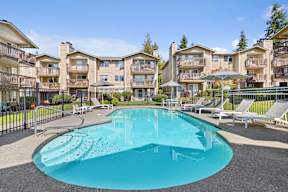 A large swimming pool in front of apartment buildings.