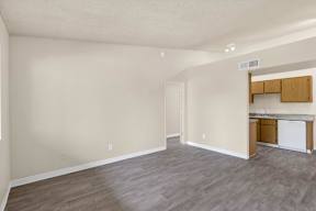 A kitchen area with a white dishwasher and wooden cabinets.