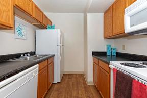 A kitchen with wooden cabinets and a white fridge.