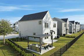 A row of houses with a black fence in front.