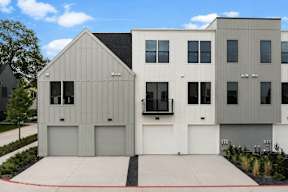 A modern house with a grey and white exterior and a black roof.