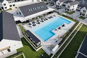 A large swimming pool surrounded by sun loungers and a building.