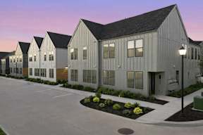 A series of modern buildings with a parking lot in front.