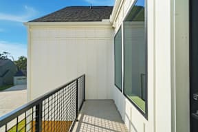 A white garage with a black railing and a window.