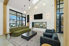 A living room with a green couch and a fireplace.