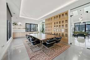 A modern dining room with a long table and chairs.