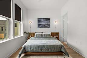 A bedroom with a large bed and a painting on the wall.