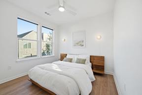 A bedroom with a large bed and a ceiling fan.