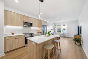A modern kitchen with wooden cabinets and a white island.