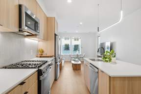 A modern kitchen with wooden cabinets and stainless steel appliances.