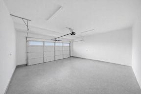 A room with a grey floor and white walls with a window and a door.