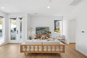 A bedroom with a bed, a painting, and a window.