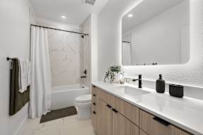 A modern bathroom with a white marble shower and a white toilet.